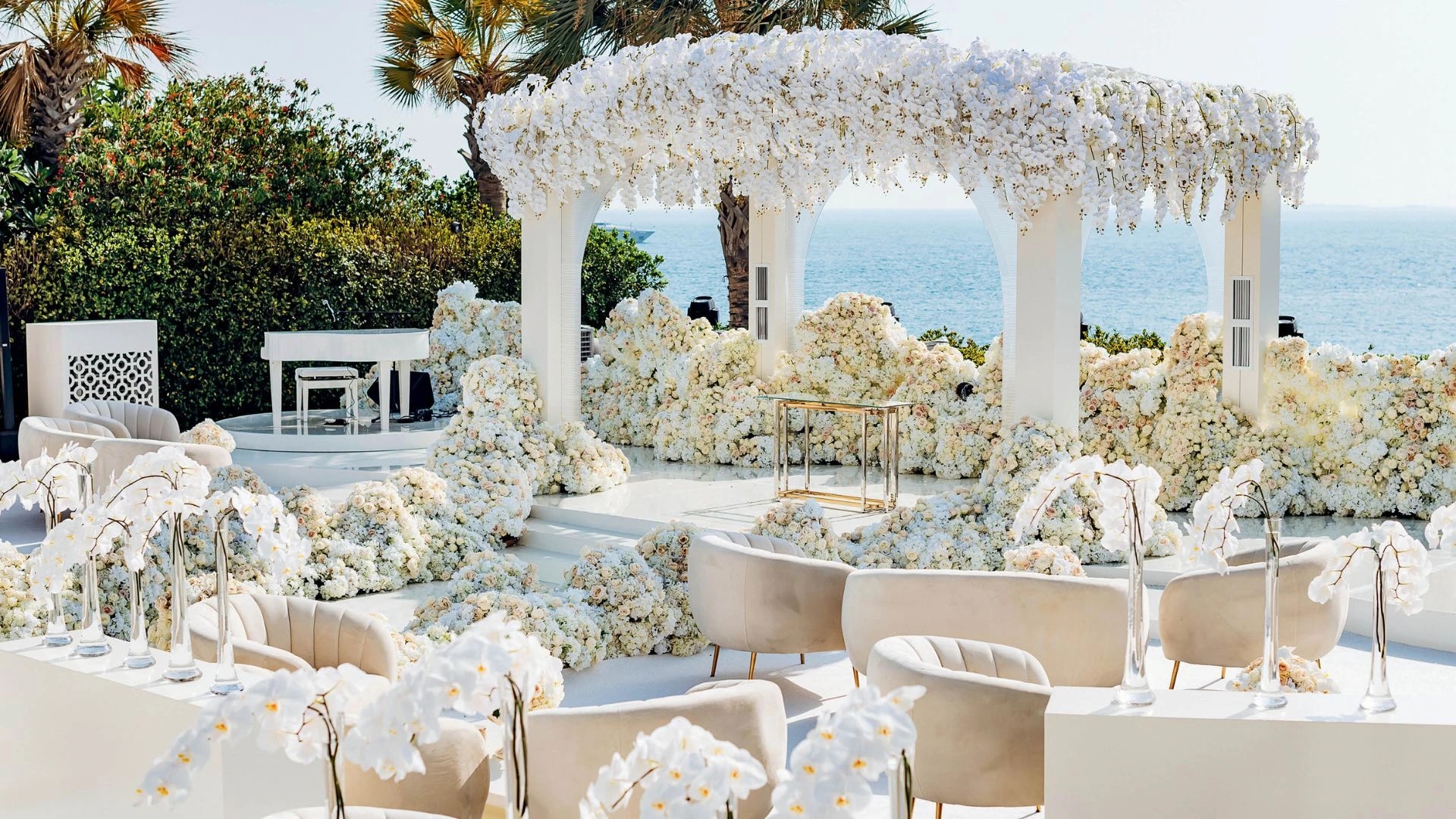 Luxurious outdoor event with floral arch and ocean backdrop
